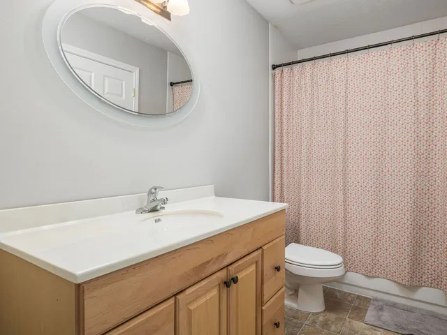 a bathroom with a sink a toilet and a mirror