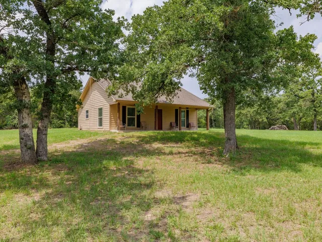 a front view of a house with yard and green space