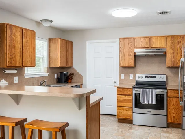 a kitchen with stainless steel appliances a stove a sink and white cabinets