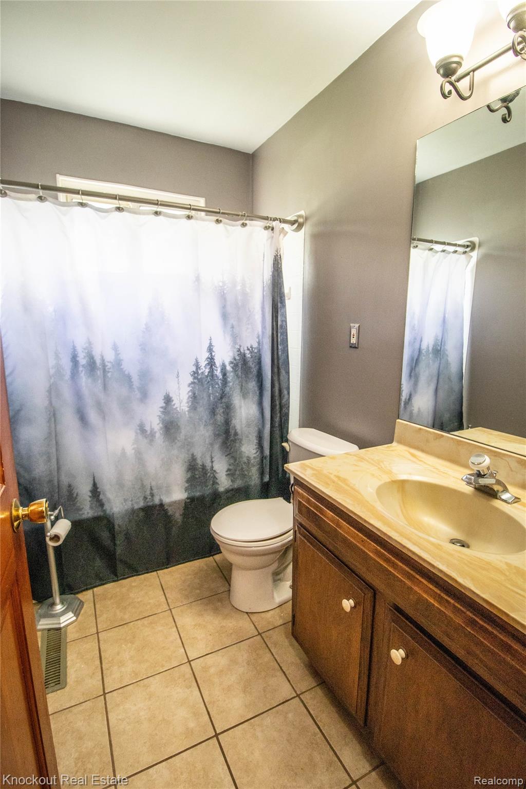 5796 East Burt Road Birch Run, MI 48415 - Photo 15 of 41 Bathroom featuring a wood-finish vanity with a built-in sink, a wall-mounted mirror, and tile flooring