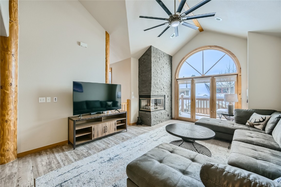 a living room with furniture a flat screen tv and a floor to ceiling window