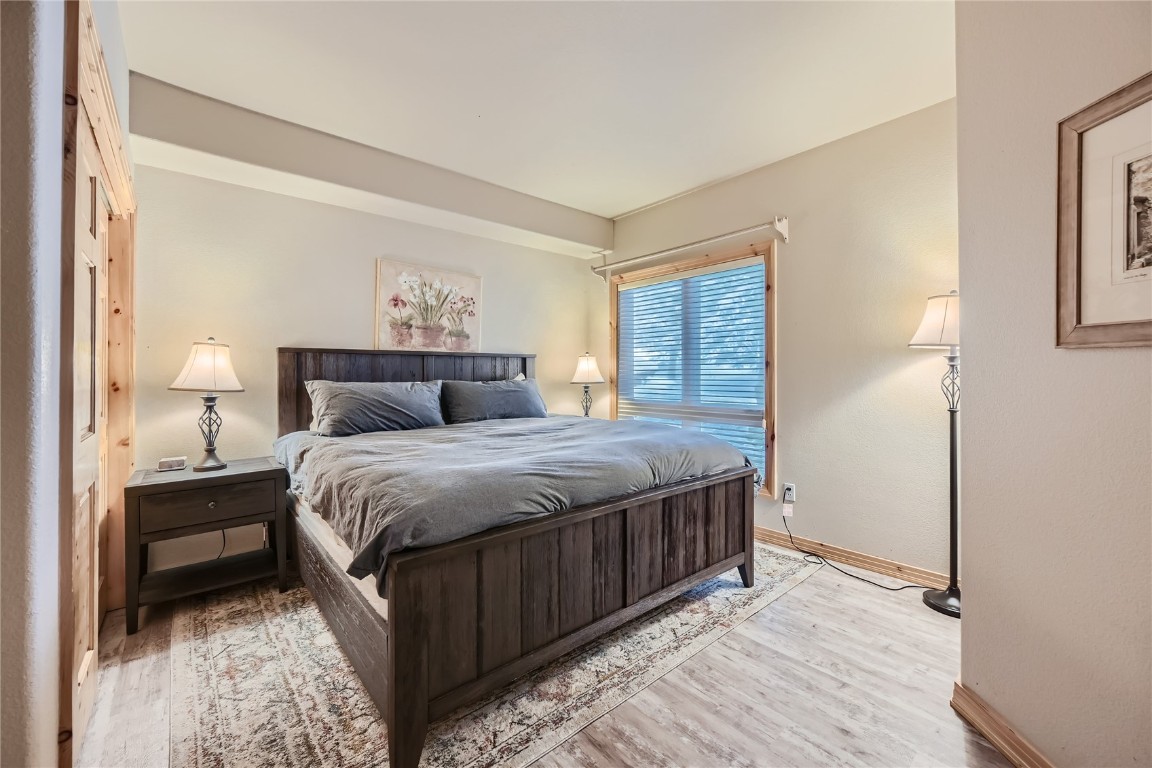 400 Kings Crown Road, Unit 400 Breckenridge, CO 80424 - Photo 16 of 40 a bedroom with a bed and wooden floor