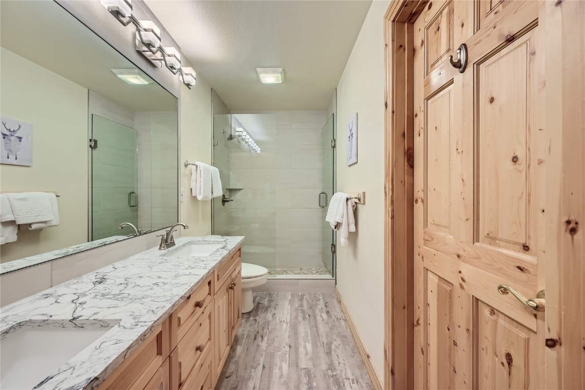 400 Kings Crown Road, Unit 400 Breckenridge, CO 80424 - Photo 19 of 40 a spacious bathroom with a granite countertop sink a mirror a vanity and a shower