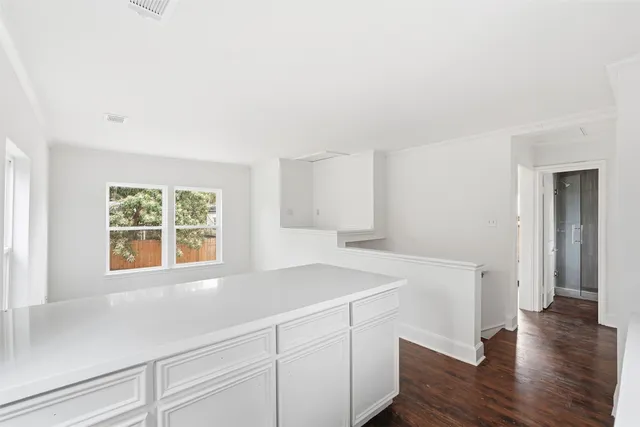 a view of a kitchen that shows a sink and dishwasher with wooden floor
