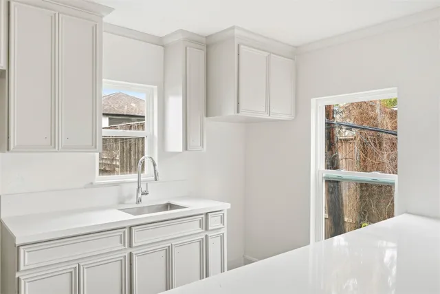 a kitchen with white cabinets and a sink