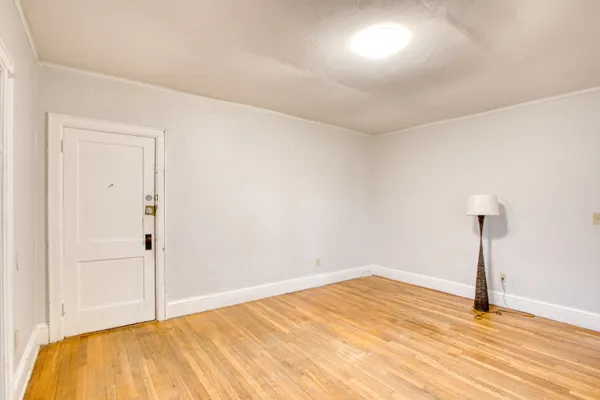 a view of empty room with wooden floor