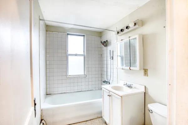 a bathroom with a bathtub sink and mirror