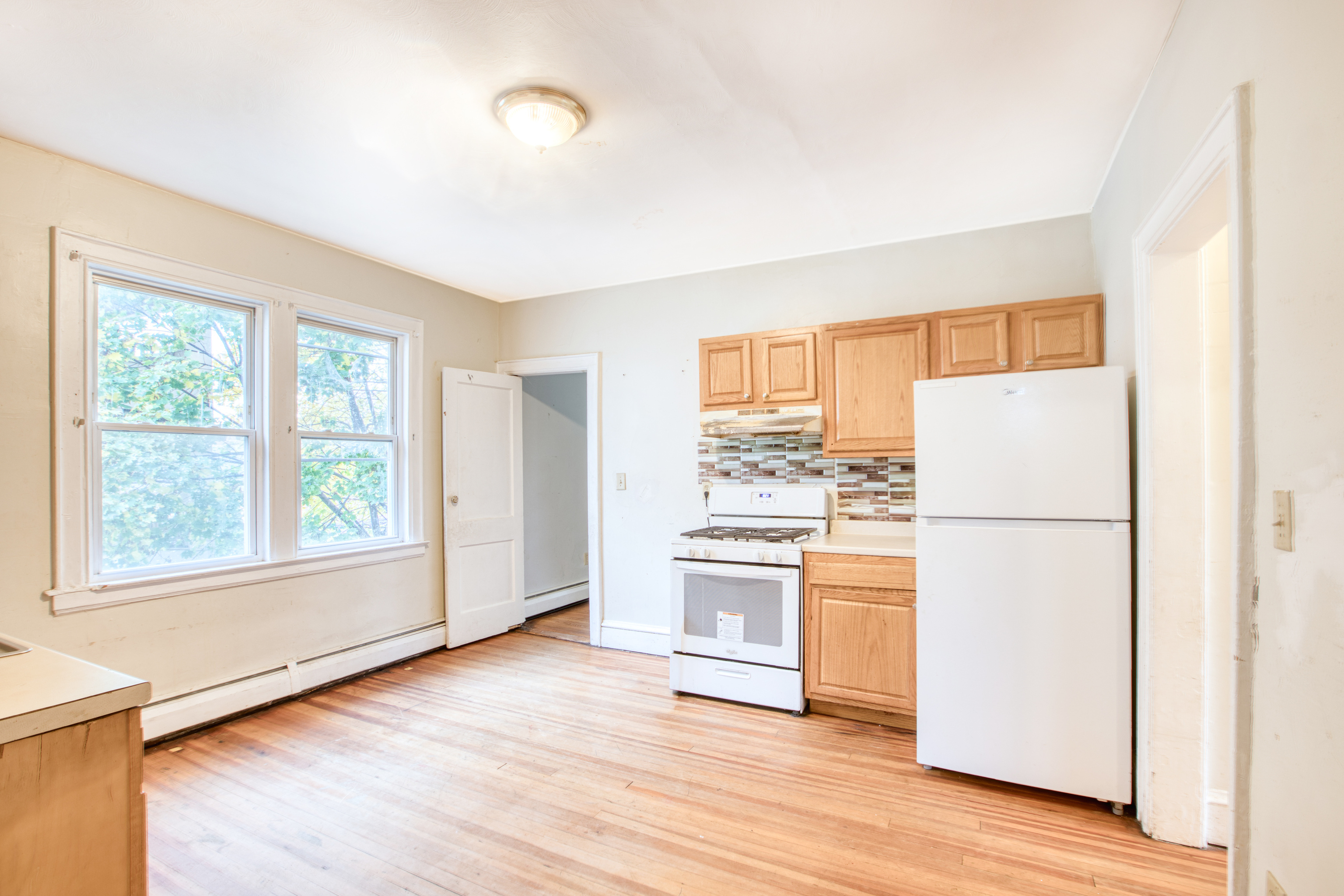 429 New Britain Avenue Hartford, CT 06106 - Photo 4 of 20 a kitchen with a refrigerator and wooden floor