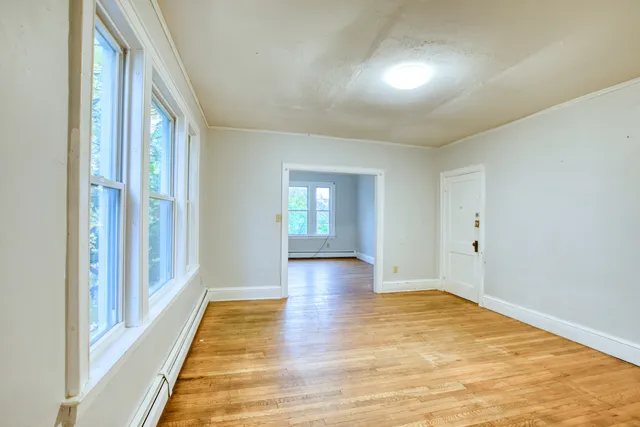 a view of empty room with wooden floor