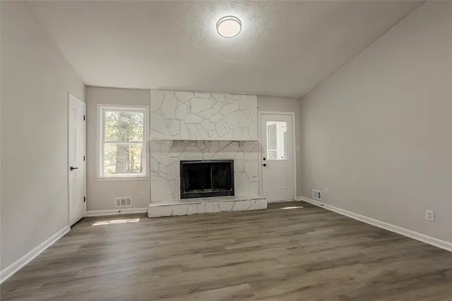 an empty room with wooden floor and fireplace