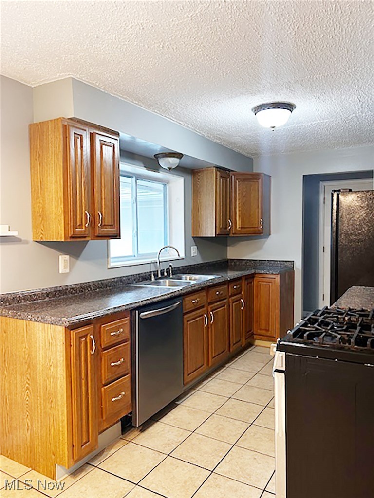743 Renninger Road Akron, OH 44319 - Photo 6 of 14 Kitchen featuring gas stove, a textured ceiling, stainless steel dishwasher, and fridge