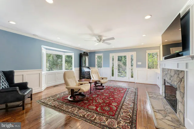 a living room with furniture a flat screen tv and a refrigerator