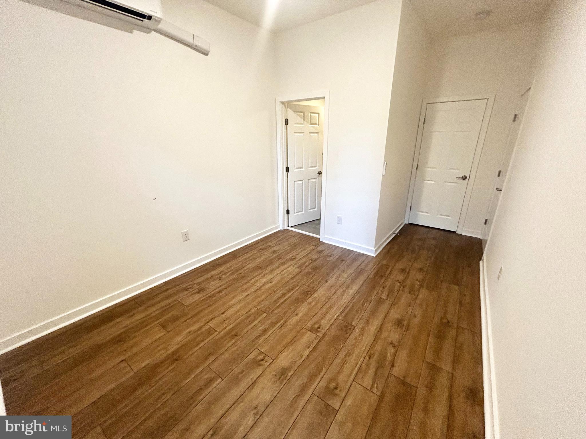 405 South 42nd Street, Unit 1R Philadelphia, PA 19104 - Photo 7 of 10 an empty room with wooden floor and a window