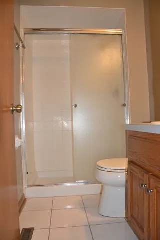 a bathroom with a granite countertop bathtub shower sink vanity and toilet
