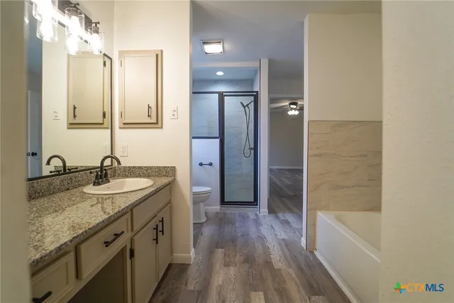 a bathroom with a granite countertop sink mirror and shower