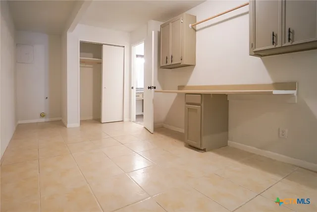 a kitchen with white cabinets and white appliances