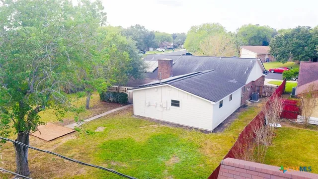 a aerial view of a house with swimming pool and large trees