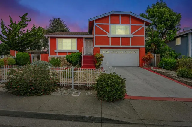 a view of a house with a small yard and potted plants