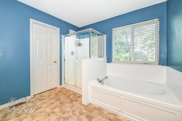 a bedroom with a bed a chandelier and a window