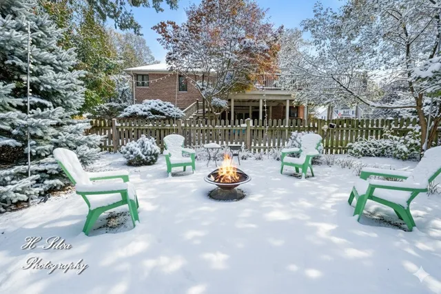 an aerial view of a house with a yard and trees all around