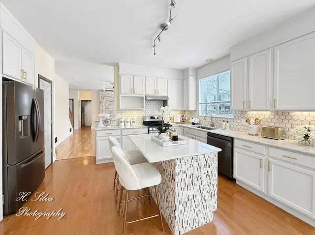 a dining room with furniture a chandelier and wooden floor