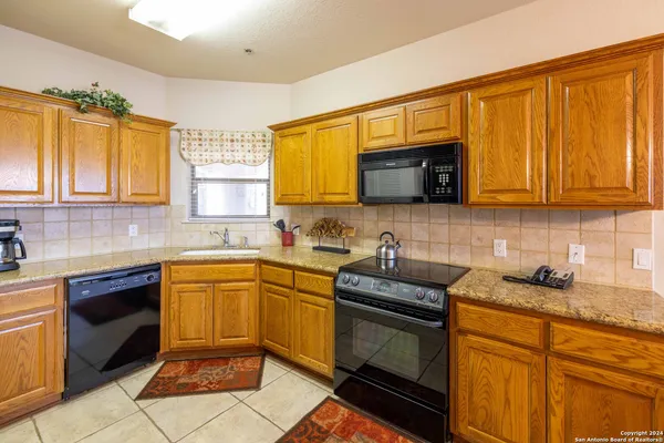 a kitchen with stainless steel appliances granite countertop stove top oven a sink dishwasher and granite countertops with wooden floor
