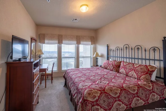 a bedroom with a bed and large windows