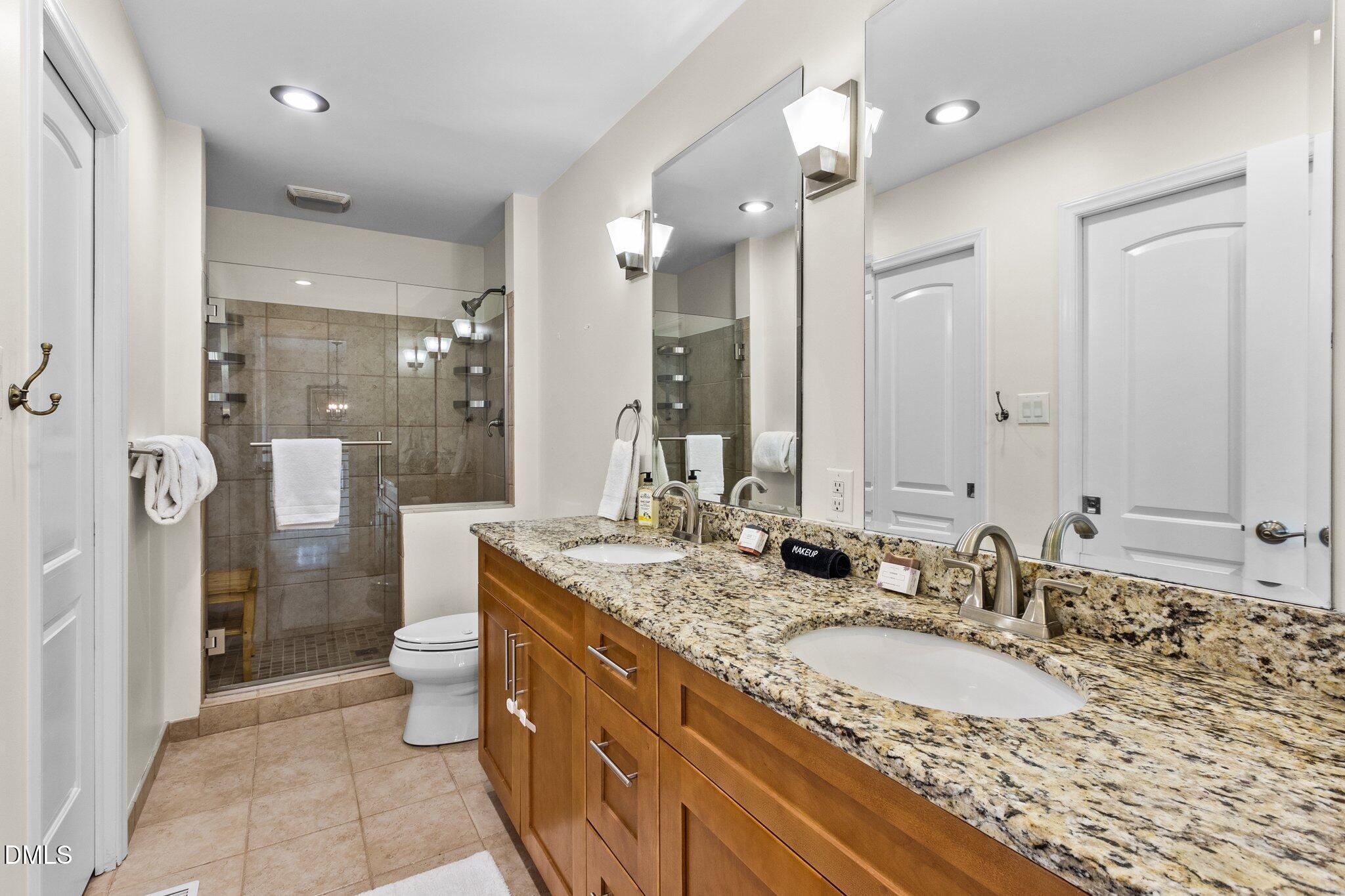 1023 Holmes Street Raleigh, NC 27601 - Photo 14 of 41 a bathroom with a granite countertop sink a toilet a mirror and shower