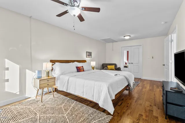 a view of a tree in front of a house with a big yard and large trees