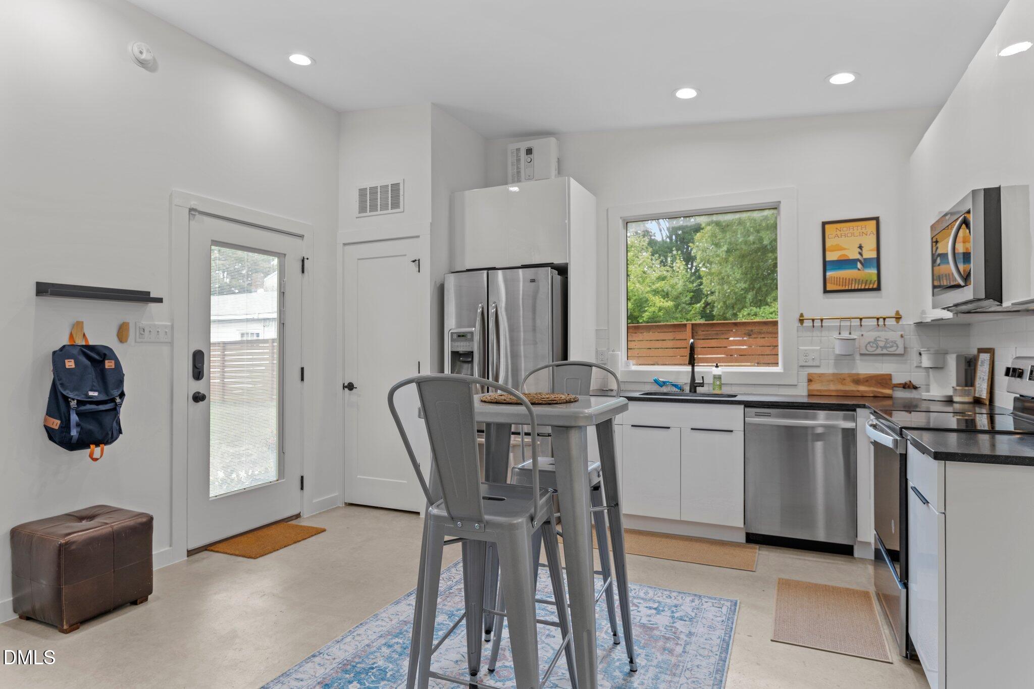 1023 Holmes Street Raleigh, NC 27601 - Photo 25 of 41 a kitchen with stainless steel appliances a table and chairs in it