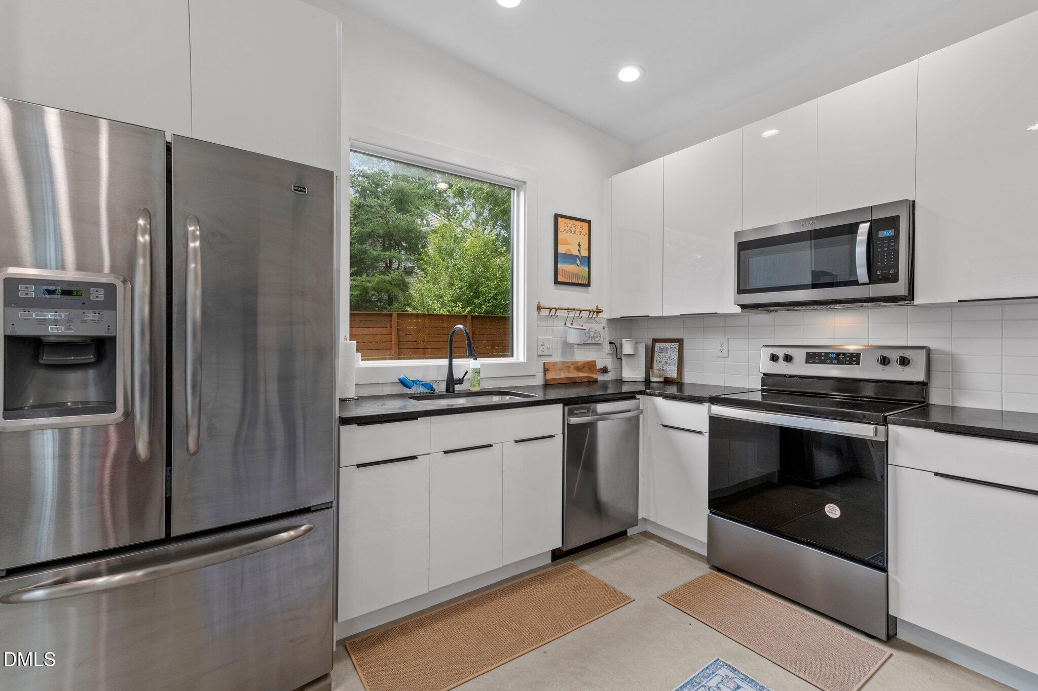 1023 Holmes Street Raleigh, NC 27601 - Photo 27 of 41 a kitchen with granite countertop a refrigerator stove and microwave