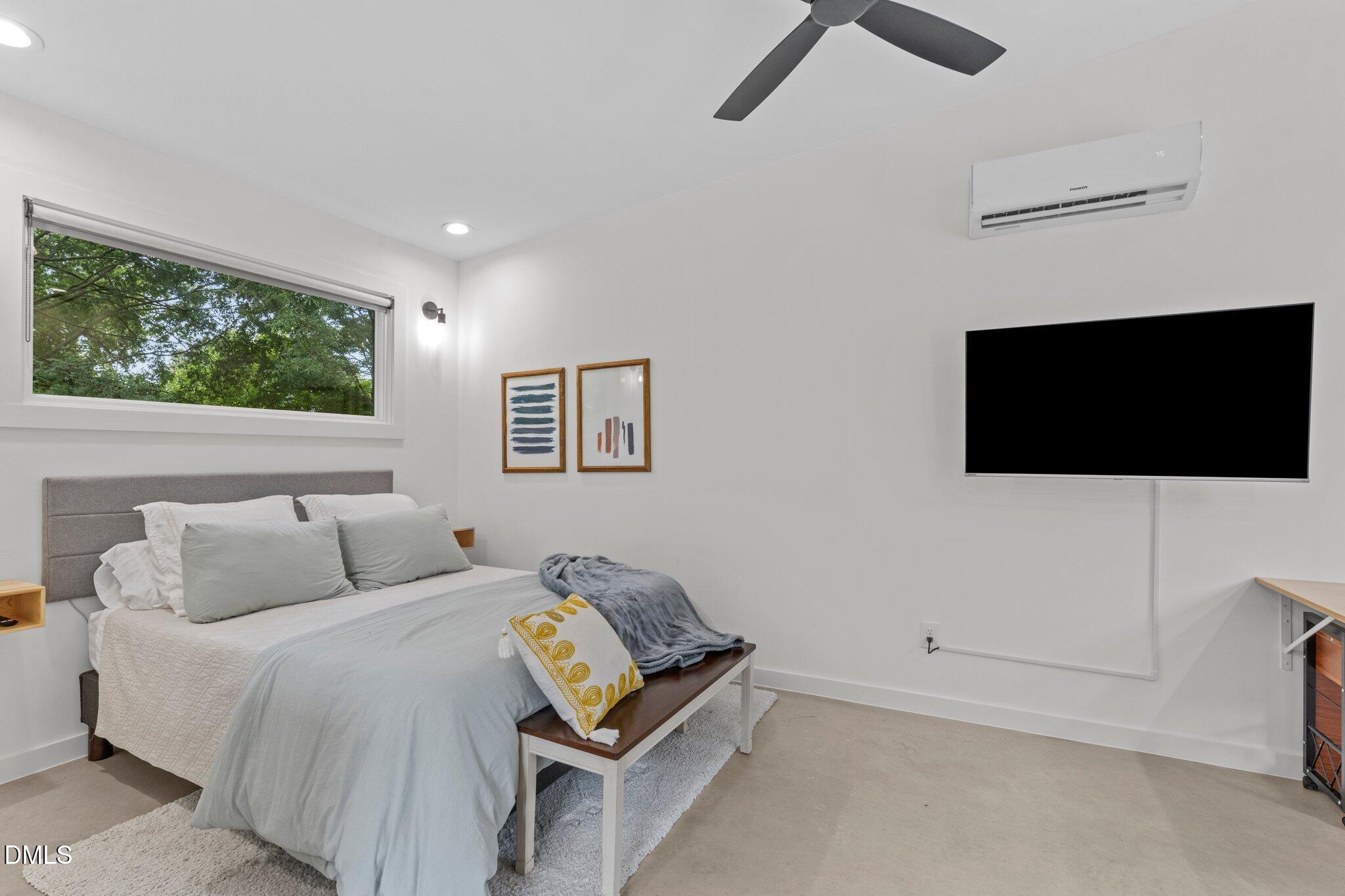 1023 Holmes Street Raleigh, NC 27601 - Photo 29 of 41 a bedroom with a bed and a flat screen tv