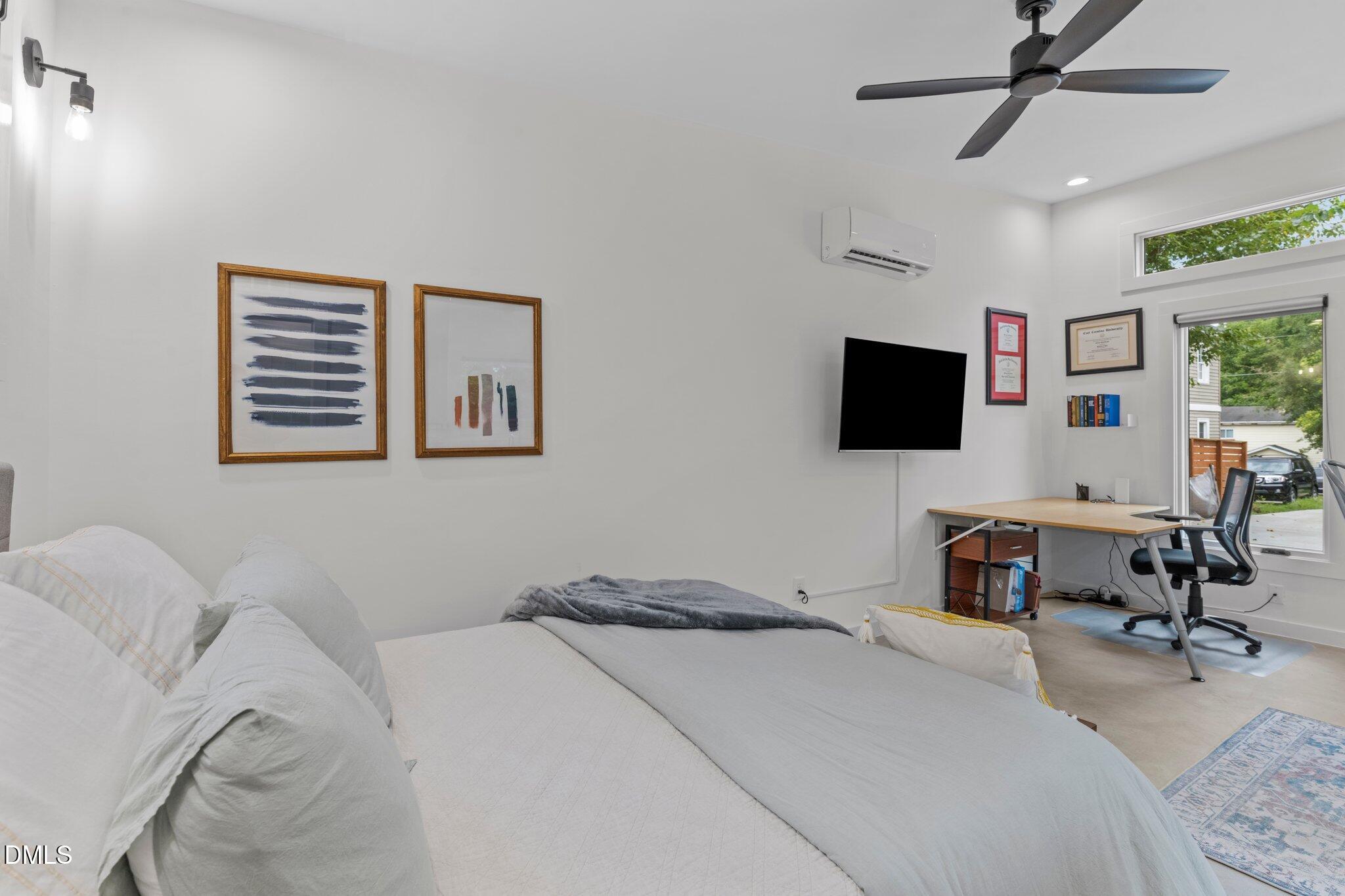 1023 Holmes Street Raleigh, NC 27601 - Photo 30 of 41 a bedroom with a bed and a flat screen tv