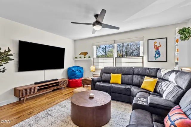 a kitchen with stainless steel appliances granite countertop a refrigerator a sink dishwasher a stove and a dining table with wooden floor