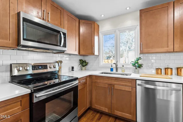 a kitchen with granite countertop a refrigerator sink and stove