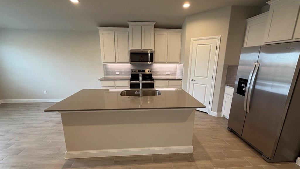 1704 River Bend Road Burleson, TX 76028 - Photo 3 of 19 a kitchen with kitchen island a stove top oven and refrigerator