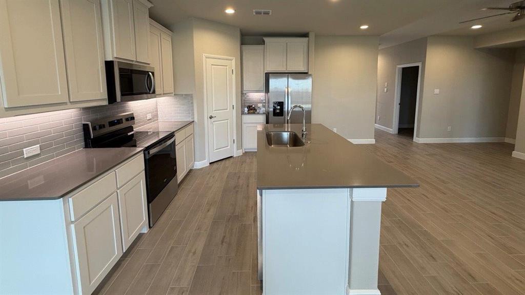 1704 River Bend Road Burleson, TX 76028 - Photo 17 of 19 a kitchen with kitchen island a counter top space a sink stainless steel appliances and cabinets