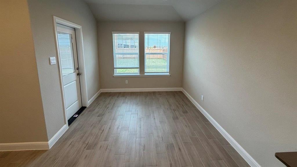 1704 River Bend Road Burleson, TX 76028 - Photo 4 of 19 an empty room with wooden floor and windows