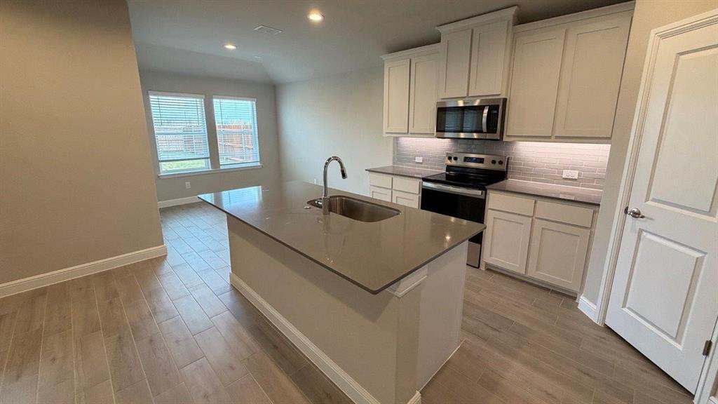 1704 River Bend Road Burleson, TX 76028 - Photo 5 of 19 a kitchen with a stove a sink and a refrigerator