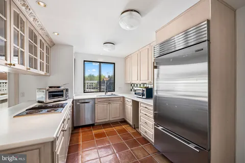 a kitchen with a refrigerator and white cabinets