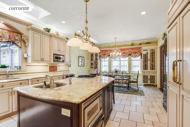 a kitchen with stainless steel appliances granite countertop a stove top oven a sink a dining table and chairs