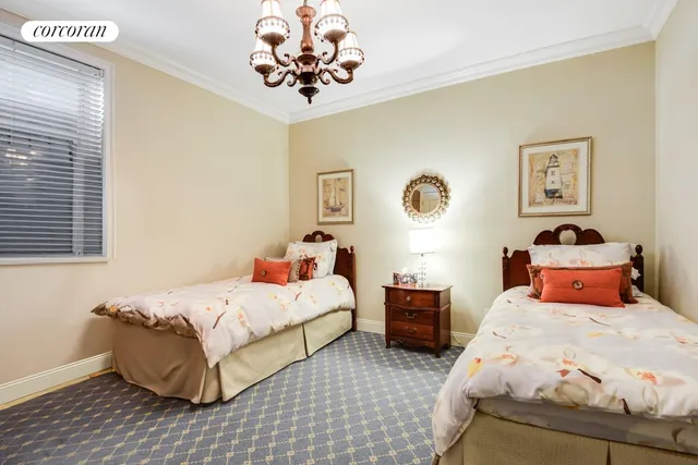 a bedroom with two beds and a chandelier