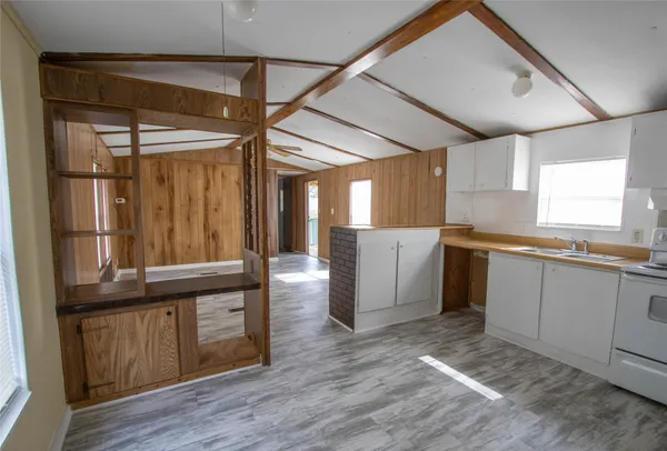 a kitchen with sink a refrigerator and wooden floor