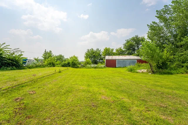 a front view of a house with a yard and trees