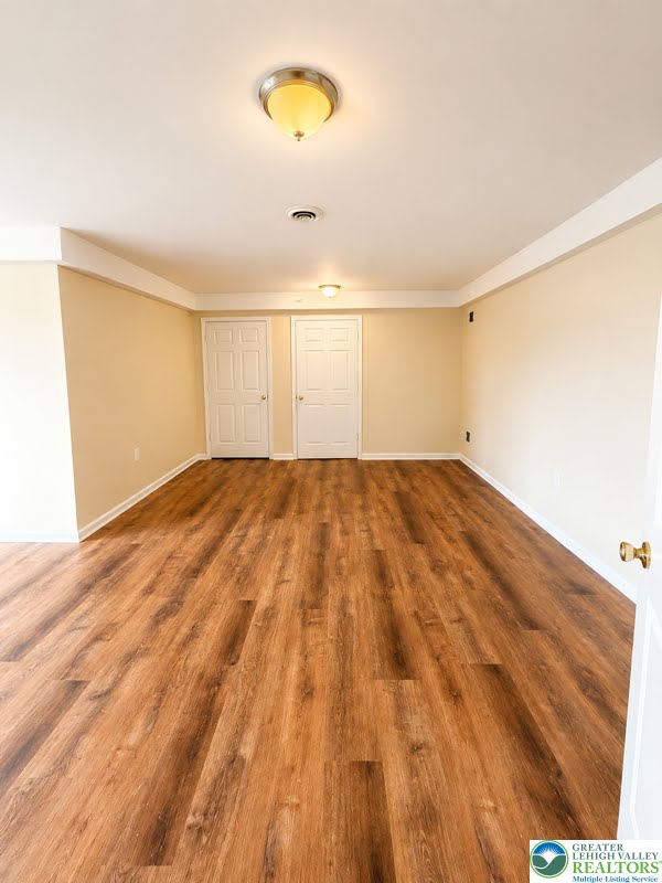3496 Linden Street, Unit UPPR Bethlehem, PA 18017 - Photo 4 of 9 Rich hardwood-style flooring extends across this spacious, empty room, ready for your personalized touch.