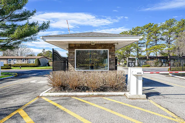 a sign that is sitting in front of a brick house