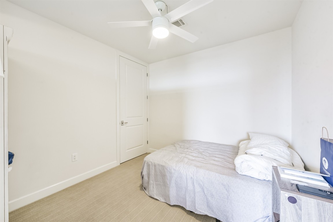 2207 Bancroft Lane, Unit 706 Houston, TX 77027 - Photo 25 of 43 a bedroom with a bed and a chandelier fan