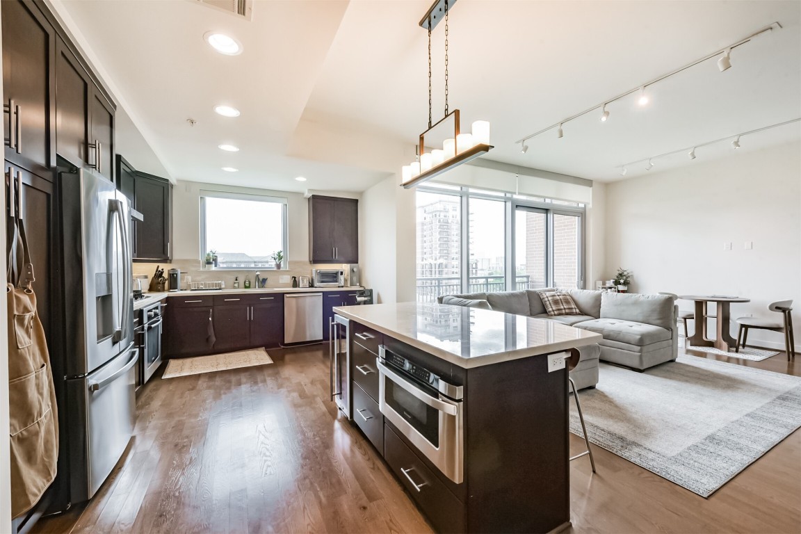 2207 Bancroft Lane, Unit 706 Houston, TX 77027 - Photo 9 of 43 a large kitchen with kitchen island granite countertop a large center island and stainless steel appliances