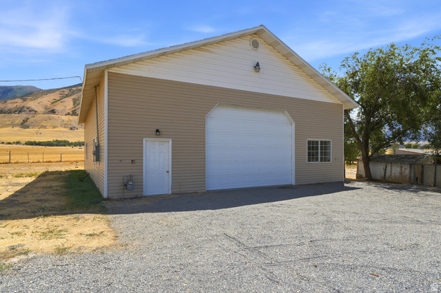 4468 North Droubay Road Tooele, UT 84074 - Photo 40 of 60 Detached auxiliary building with a large roll-up door, side entry door, and multi-pane window