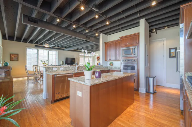 a kitchen with stainless steel appliances granite countertop a sink window and cabinets